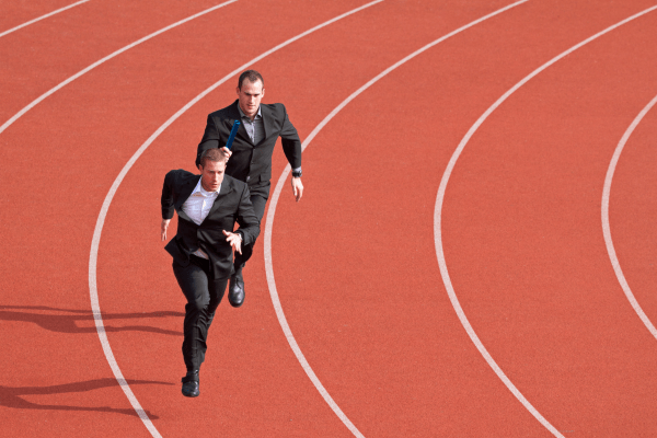 deux hommes en costumes sur une piste de course
